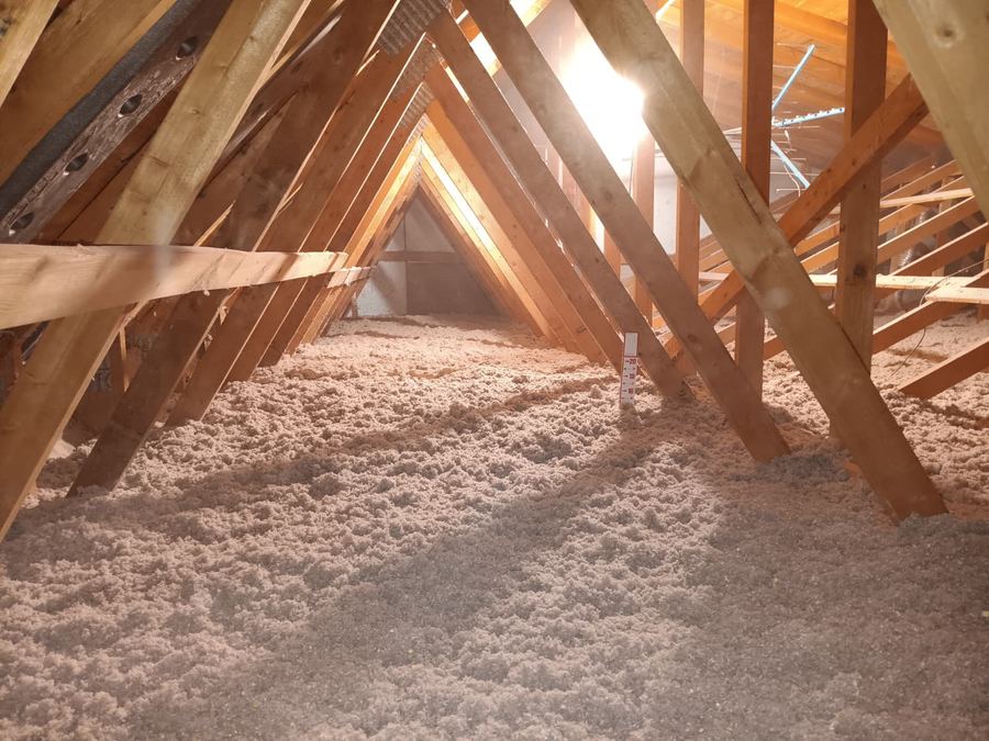 Attic floor covered with an even layer of blown-in cellulose insulation