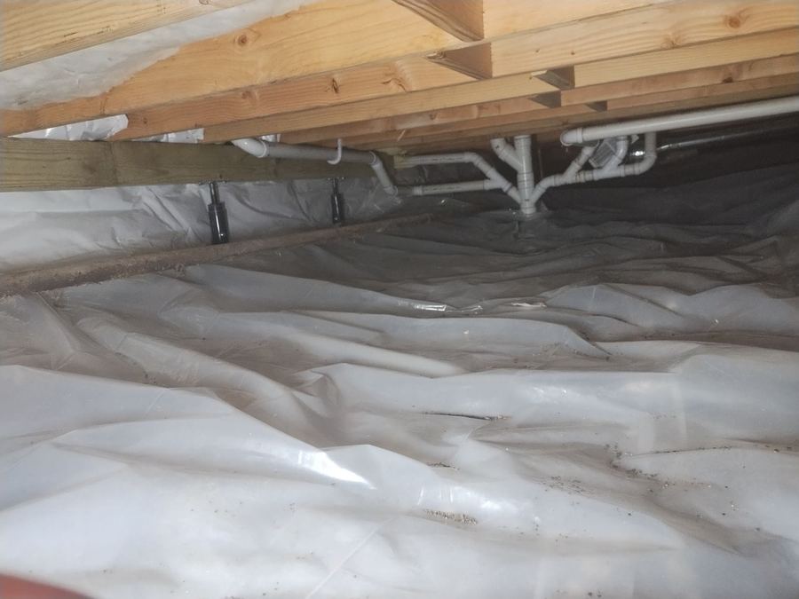 Crawl space floor covered edge to edge with a sealed vapor barrier