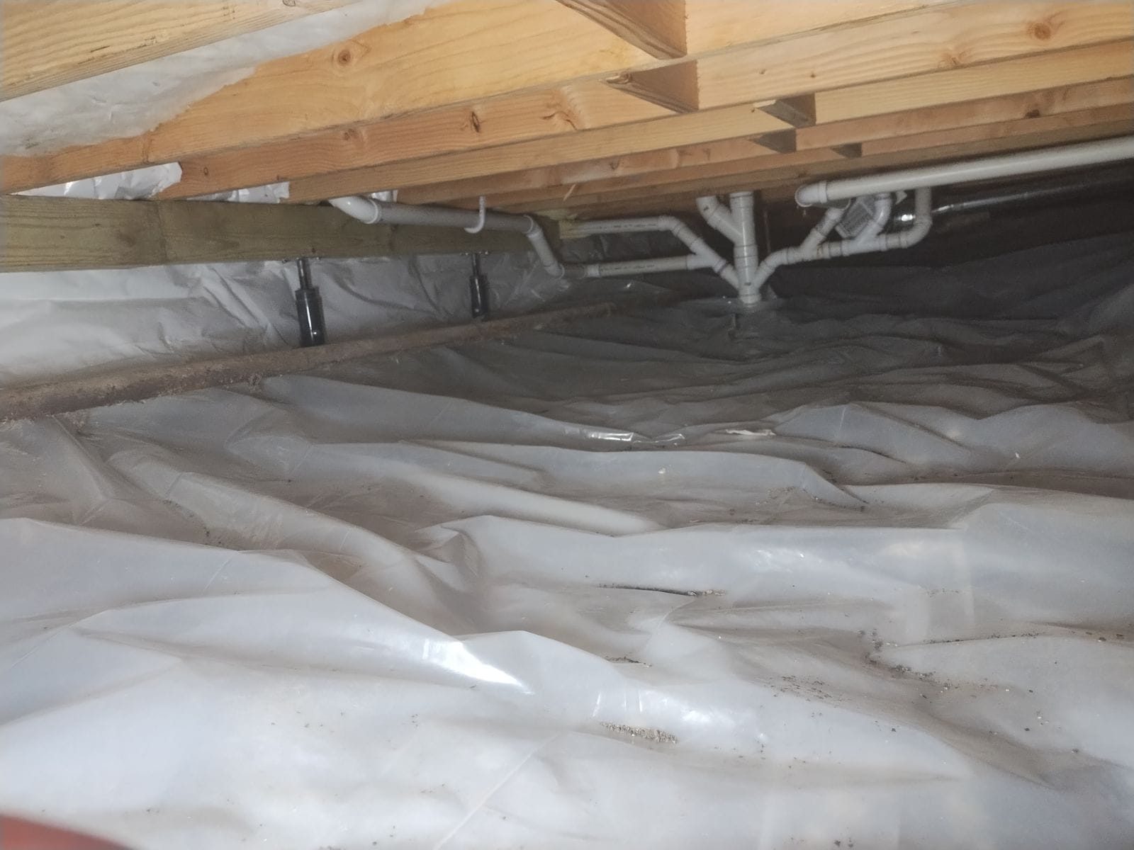 Crawl space floor covered edge to edge with a sealed vapor barrier